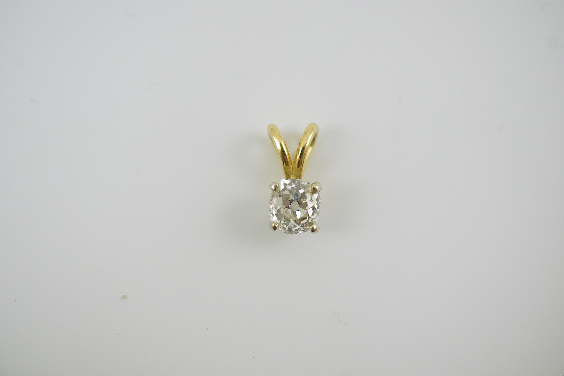 A gold and solitaire diamond set small pendant